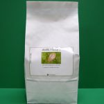 white paper bag with green printed label against green background