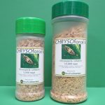 Two bottles of Chrysotoxerces ornatus seasoning with green caps on a green background.